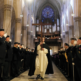 Flanked by Fourth Degree honor guard, Dominican Father Jonathan Kalisch carries a replica Quincentenary Cross of the New World through St. Patrick's Cathedral.