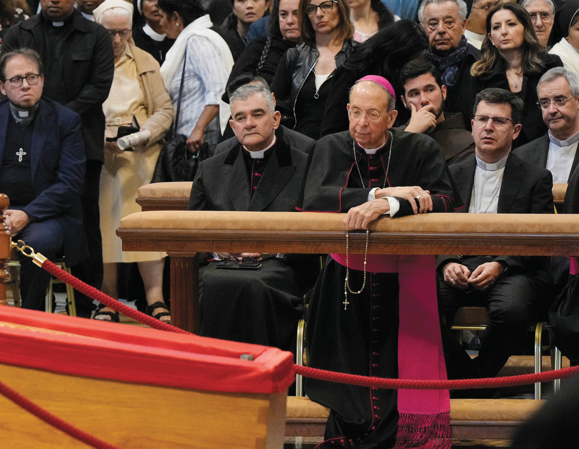 Archbishop William Lori kneels before the wooden coffin of Pope Francis