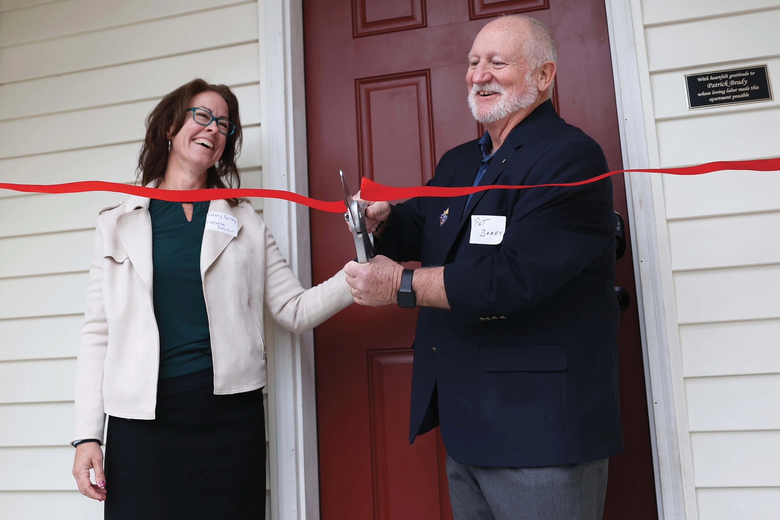 Tiffany Farley joins Pat Brady in cutting the ribbon on the new maternity home addition in Bowie, Md.