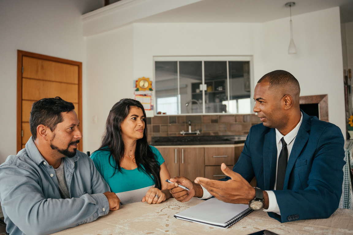 Insurance agent meeting with a couple in their home.