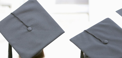 Graduating students are seen wearing graduation caps.