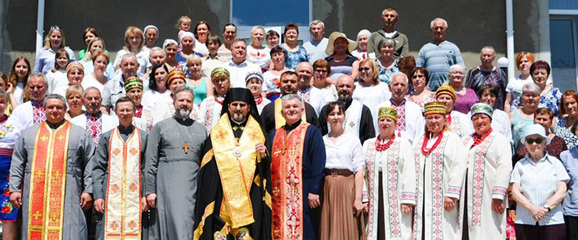 Bishop Mykhailo Bubniy (center), exarch of Odesa, Ukraine, and state chaplain of the country’s Ukrainian Greek Catholic Knights, and Father Vasyl Kolodchyn (to the bishop’s left), director of Caritas Odesa, join residents, parishioners and local officials for the consecration of the Kovcheh (“the Ark”) shelter in Rakulove, Ukraine,