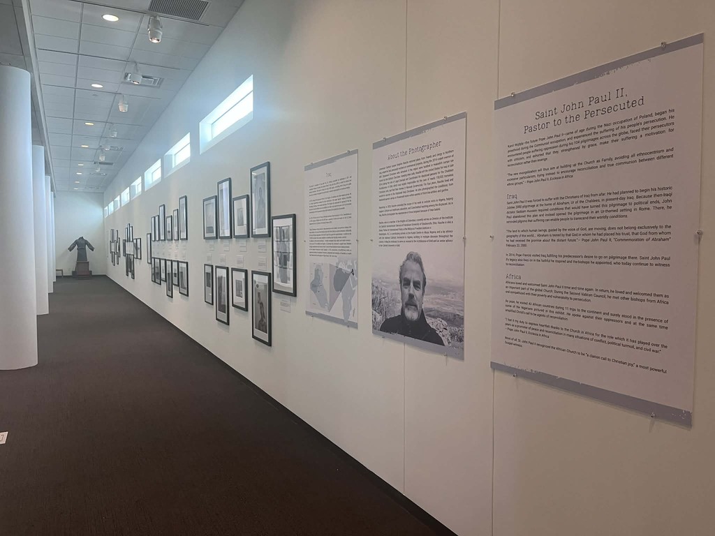 Black and white photographs featuring persecuted Christians line the walls at the Shrine. At the end of the hall stands the remains of a statue of Christ the Redeemer from a destroyed church in Nigeria.