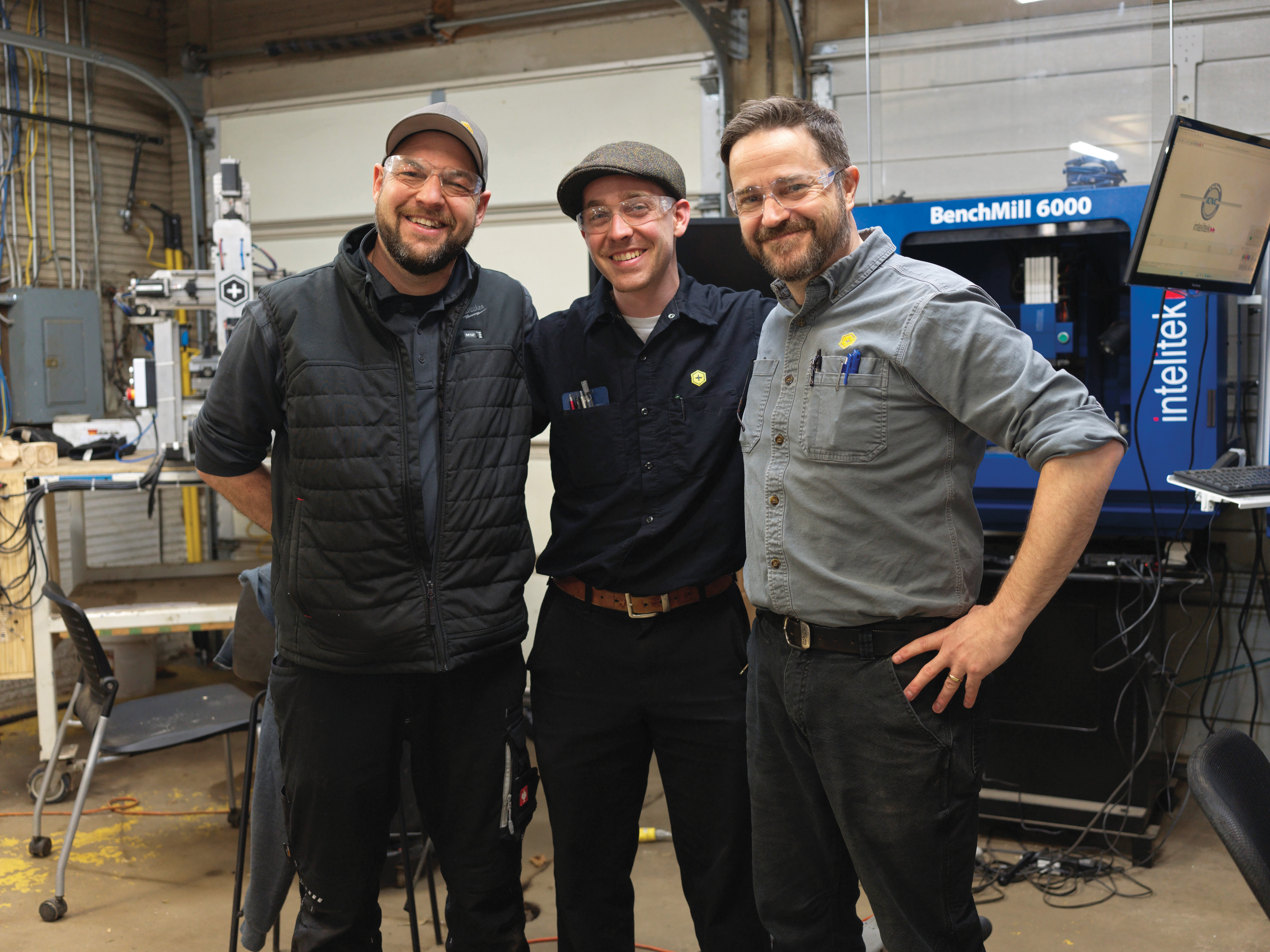 Phelps (right) stands with student and brother Knight Abe Forget (center) and Andy Beach, director of manufacturing services.