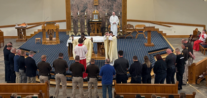 Father Emmanuel Udoh (center), pastor of Ss. Peter and Paul Church and faithful friar of Father George P. Boehmicke Assembly 2753 in Hopkinsville, Ky., and Father Conrad Jaconette, associate pastor and a brother Knight, bless about 20 first responders during a Blue Mass organized by the assembly. At a reception afterward, students from Ss. Peter and Paul School presented thank-you cards to the honorees.