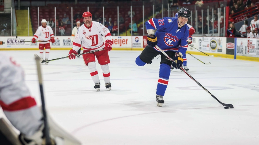 John Scott (right), an eight-year veteran of the NHL, takes a shot on goal during the 2025 NHL Alumni Game.