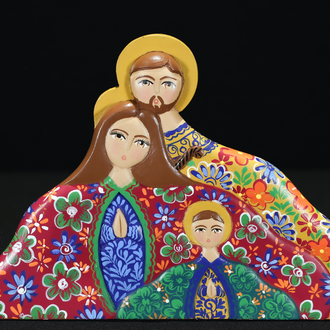 Photo of a painted wood depiction of the Holy Family in colorful garments. Their heads are surrounded by a halo and their hands are clasped in prayer. 