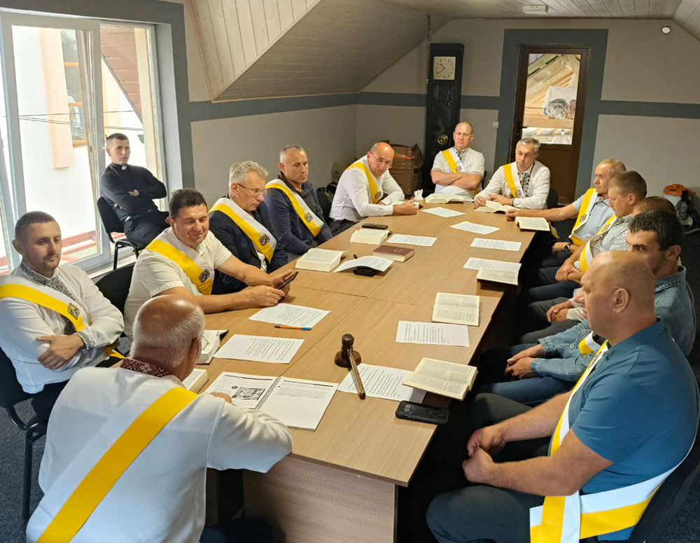 Mens sitting at a table for a council meeting.