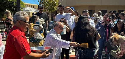 Past Grand Knight Vince Calderon of Palmdale (Calif.) Council 4229 holds a bowl of holy water for Father Guillermo Martinez, pastor of St. Mary Catholic Church, as he blesses parishioners’ pets on the feast day of St. Francis of Assisi, Oct. 4. Council 4229 has helped organize the pet blessing annually since 2008. 