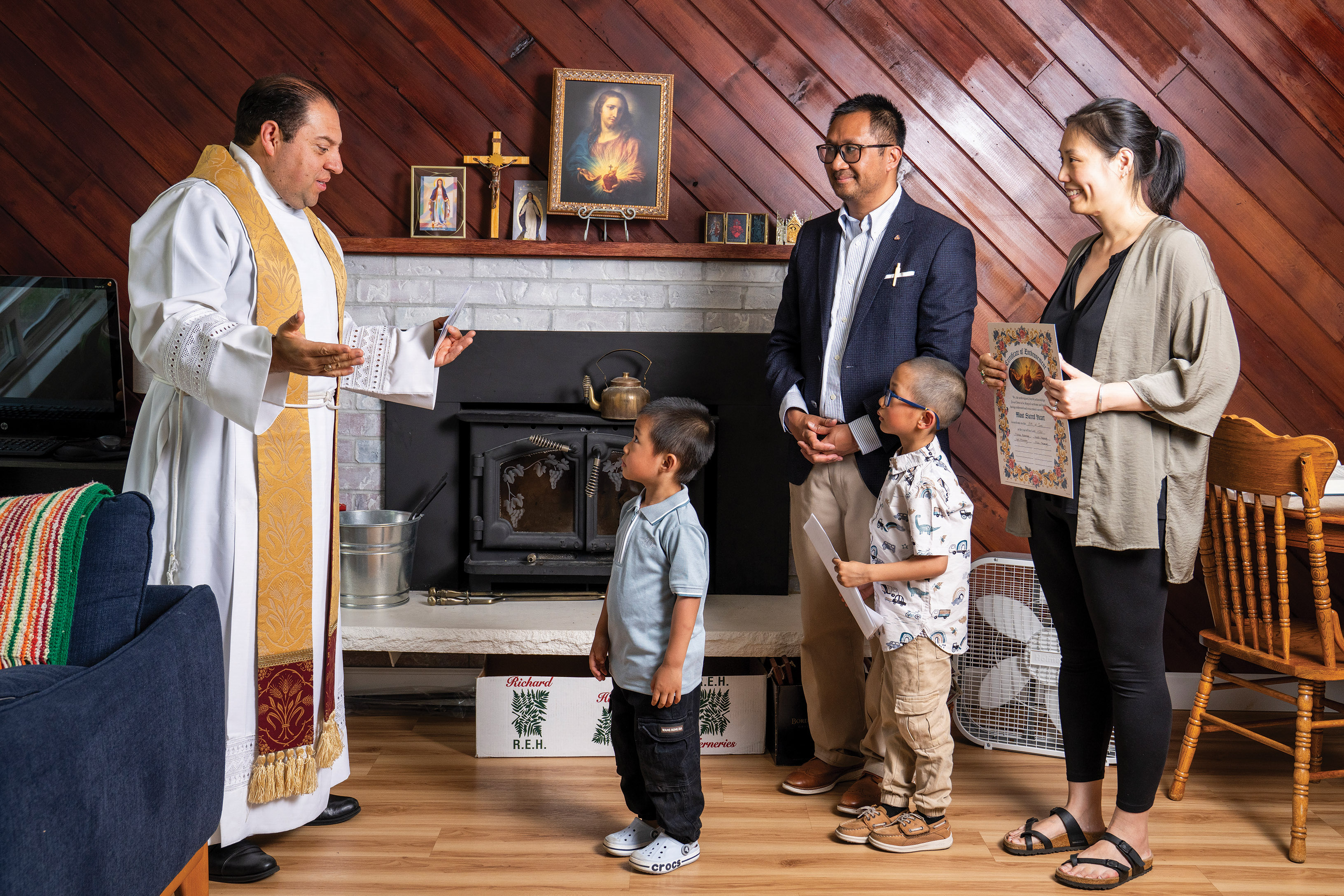 Cyril Macaraeg and his family pray with Father Jos&eacute; Alvarez during their Sacred Heart enthronement ceremony at their home.
