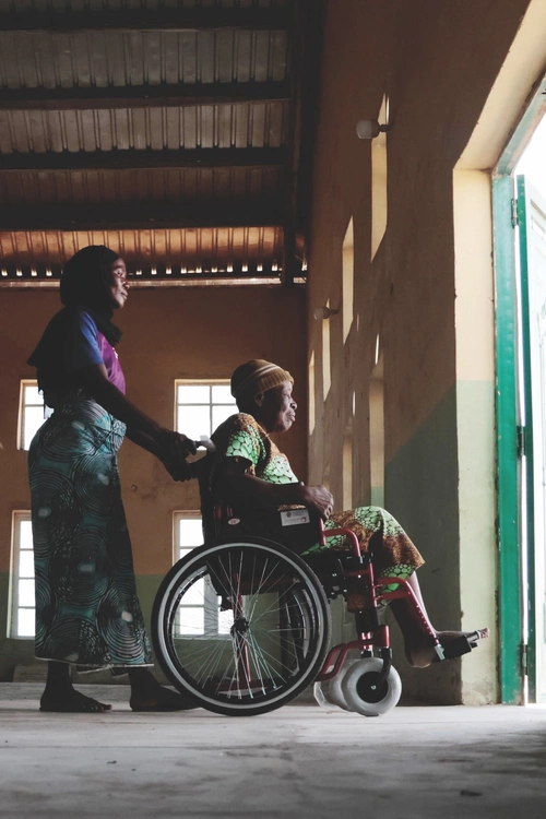 A woman and her caretaker leave St. Stephen Church in Yola, Nigeria, after receiving a wheelchair from the Knights of Columbus.