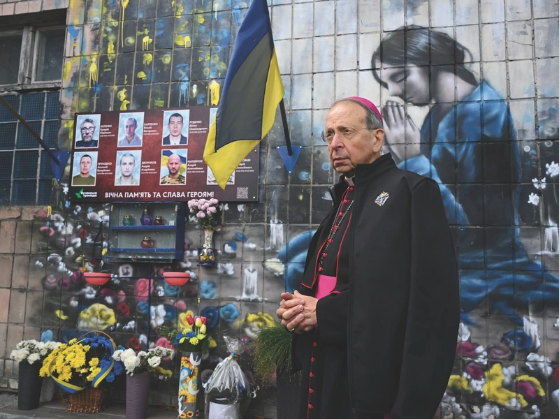 Supreme Chaplain Archbishop William Lori pauses in Bucha, Ukraine, to pray for men executed by Russian forces.