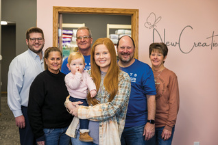 Karlee Jones and her daughter, Wrenlee, stand with board members and volunteers of New Creation Pregnancy Resource Center in Carroll, Iowa