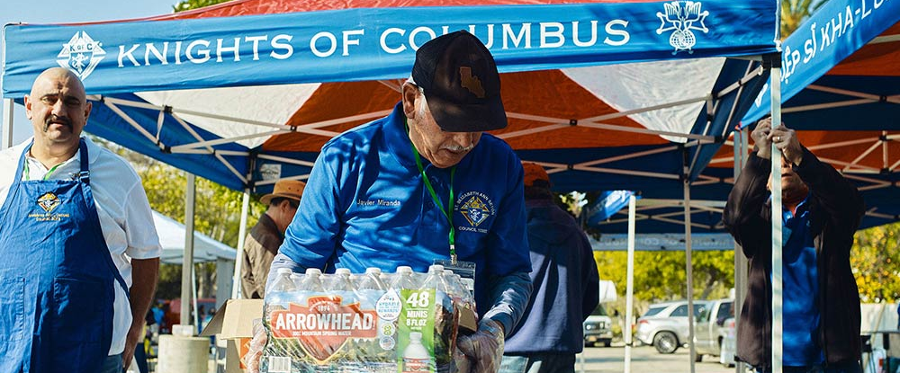 Javier Miranda, a member of St. Elizabeth Ann Seton Council 10302 in Rowland Heights, Calif., moves a case of water during a food and supply distribution in Pasadena on Jan. 18 to assist people affected by the wildfires. (Photo by Slav Zatoka)