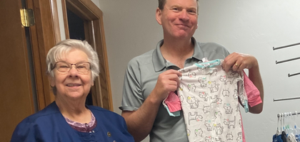 James Cullen, family director for Father Marquette Council 2984 in Kewaunee, Wis., and Rose, a volunteer with the Alexandrina Pregnancy Resource Center, display some of the more than 600 baby onesies and sleepers collected by Knights. 