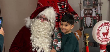 Grand Knight Terry Cornell of St. Michael the Archangel, Patron of Police Council 12173 in Chicago, dressed as Santa, poses for a picture with a student at Blair Early Childhood Center, a school for children with disabilities. Knights and volunteers from other community organizations visited the school to distribute toys to about 125 students.