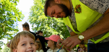 Nazar Bachynskyi of Patriarch Josyf Slipyj Council 18687 in Velyka Berezovytsia, Ukraine, assists a young boy with an art activity during a Kinder Mobile event. The Knights of Columbus has partnered with the Knights of Malta to support Kinder Mobile, which travels throughout Ukraine to offer psychological and emotional support to children in war-torn areas through art and games. (Photo by Andrii Gorb)