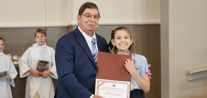 Charlie Mullaney, a member of St. Joseph Council 4599 in Marietta, Ga., presents a $500 scholarship to Olivia Young, a fifth grader at St. Joseph Catholic School, for the 2025-26 school year. 