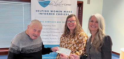 Past Grand Knight Patrick Monahan of Father James P. Conroy Council 4403 in Bettendorf, Iowa, presents a $400 grant from the Supreme Council to staff from the local Women’s Choice Center. 