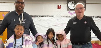 Lawrence Kuchenreuther, a member of West Allis (Wis.) Council 3095, and Tarrynce Robinson, superintendent of West Allis–West Milwaukee Schools, present Pershing Elementary School students with new coats from the council’s Knights of Columbus Coats for Kids program. The council donated 450 coats to the school, local parishes and other charitable organizations in the area. Over the past three years, the council has distributed about 1,500 coats through the program.