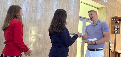Max Sherry, a member of St. Hilary Council 14551 in Fairlawn, Ohio, and an eighth-grade teacher at St. Hilary School, presents a Bible to a student during an all-school Mass and enthronement ceremony at St. Hilary Church. The council worked with the school to provide 350 Bibles, valued at $7,500, to students in grades 5-8.