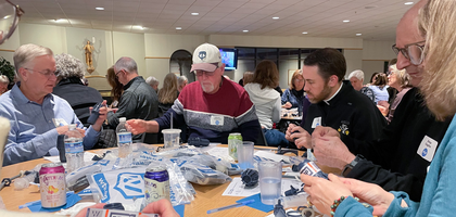 Knights and other volunteers assemble water filters during a service event organized by Father John Deere Council 4914 in Prior Lake, Minn. 