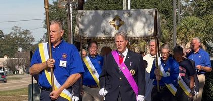 Knights from St. Alphonsus Liguori Council 2807 in Greenwell Springs, La., carry a crucifix and canopy over Father Jason Palermo, pastor of St. Alphonsus Liguori Church and council chaplain, as he carries the monstrance during a Eucharistic procession on the feast of Christ the King. More than 100 parishioners walked about a mile around the church grounds while praying the rosary. The procession ended with Benediction at the church.