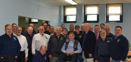 Members of Msgr. John C. Seidenschwang Council 11836 in Garden City, N.Y., gather around Larry Marquino, a brother Knight who has used a wheelchair since a skiing accident, at St. Anne Parish. Council 11836 donated $25,000 to assist Marquino with medical expenses and home modifications to accommodate his mobility needs.