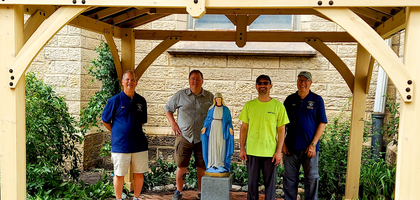 Members of St. Bernadette Council 16376 in Westlake, Ohio, gather under a grotto at St. Stephen Parish in Cleveland. The council designed and built the grotto to protect a statue of Mary at the request of Father Caroli Shao, pastor and a member of the council. A parish group provided the materials for the project, which Knights and volunteers completed over three days.