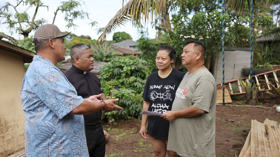 Knights speak with Josephine and Fredrick Diana, whose home in Waialua, Hawaii, was damaged by floodwaters. 