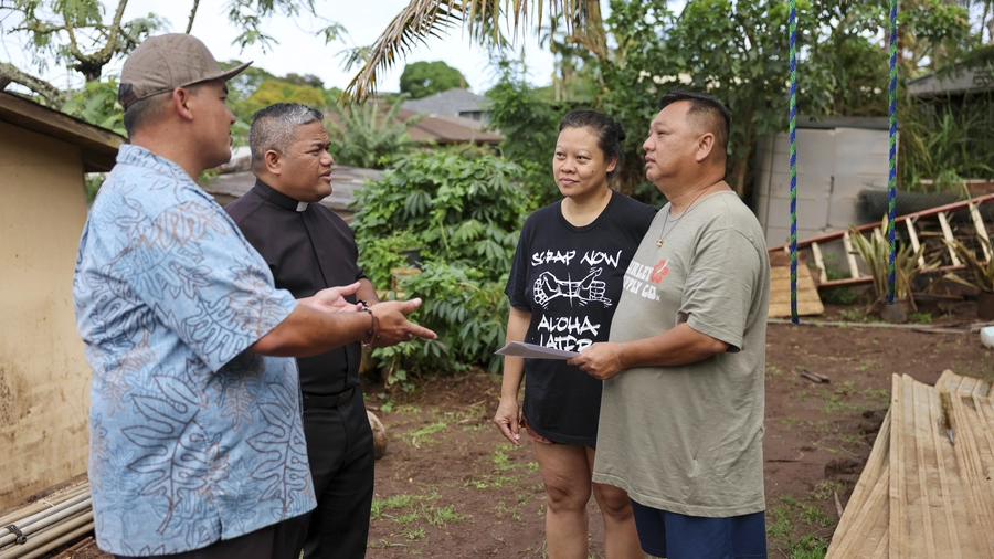Knights speak with Josephine and Fredrick Diana, whose home in Waialua, Hawaii, was damaged by floodwaters. 