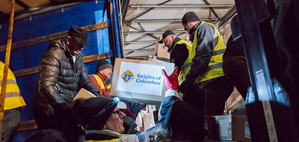 Knights handing packages off of a truck.