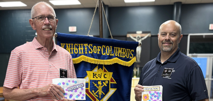 Grand Knight Travis Temples (right) and Dan Hammond of Santa Maria Council 2829 in Winston-Salem, N.C., hold appreciation cards from the Children’s Center of Winston-Salem and Forsyth County School District. Council 2829 had made several donations, totaling over $13,000, to support programs for students with intellectual disabilities at 10 local Catholic and public schools. 