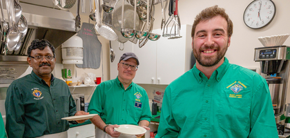 Knights from St. Agnes Council 16817 in Halifax, Nova Scotia, prepare dinner plates for people in need at Hope Cottage, a local soup kitchen. Council members cook and serve meals there four times a year, providing food for about 70 people during their most recent visit. (Photo by Aaron McKenzie Fraser)