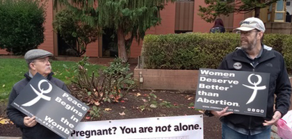 Grand Knight Jerry Glisson (right) and Past Grand Knight Rigo Moreno of Holy Redeemer Council 12899 in Vancouver, Wash., hold signs in defense of life in front of the Clark County Courthouse during Clark County Right to Life’s annual Remembrance of Abortion Victims. About 30 people, including roughly a dozen Knights, participated in the rally, which included prayer and personal testimonies.