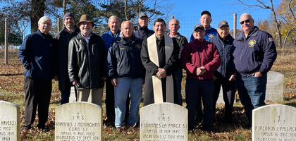 Members of Father John LaFarge, S.J. Council 4012 in Yorktown Heights, N.Y., gather behind the tombstone of their council’s namesake and founder — a prominent advocate for interracial justice in the early 20th century — after a memorial service at Loyola Seminary Cemetery in Shrub Oak.