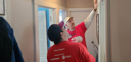 Michael Sciarappa (left) and Ray Palczynski of Father James P. Conroy Council 4403 in Bettendorf, Iowa, install a smoke alarm in a Davenport home. 
