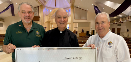 Grand Knight James Naples (left) and Deputy Grand Knight Richard McGrail of St. Bernadette Council 13042 in Port St. Lucie, Fla., present a $20,000 check to Father Victor Ulto, pastor and council chaplain, to offset the cost of new flooring in the parish life center at St. Bernadette Catholic Church.
