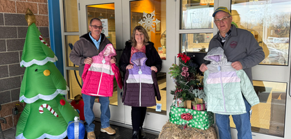 Past Grand Knight Paul Perry (left) and treasurer Mike Dostoler of Webster (Mass.) Council 228 present some new winter jackets to Kristin Mayotte, deputy director of the Boys & Girls Club of Worcester. 