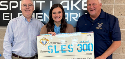 Grand Knight Jed Skogerboe (right) of Iowa Great Lakes Council 5043 in Spirit Lake, Iowa, and Past Grand Knight Rob Waterhouse, a field agent based in Spirit Lake, present a $300 check to Principal Jessica Vancura of Spirit Lake Elementary School. The proceeds were used to purchase winter clothing for students in need. The council also distributed 25 coats at Terril Elementary School through the Knights of Columbus Coats for Kids program.