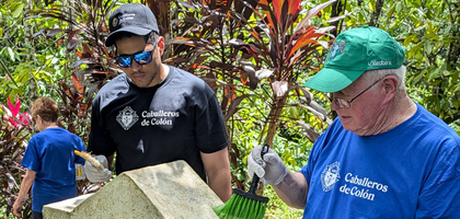 Two Knights in casual clothing painting the Stations of the Cross. 