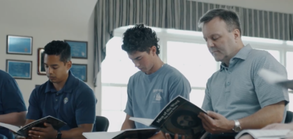 Three knights sitting and reading "Men of the Word".