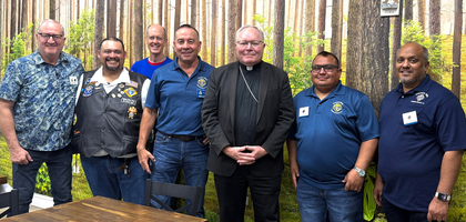Knights from Father Emil Platte Council 5052 in Dallas gather with Bishop Edward Burns of Dallas after a family rosary night at Mary Immaculate Catholic Church. About 600 people attended the prayer service and dinner that followed. The council has helped organize the event for the past three years, with Knights serving as ushers, preparing dinner and more.