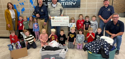 Knights from Iowa Great Lakes Council 5043 in Spirit Lake, Iowa, present guidance counselor Kim Johnson and students from Spirit Lake Elementary School with winter gear donated through the Knights of Columbus Coats for Kids program.