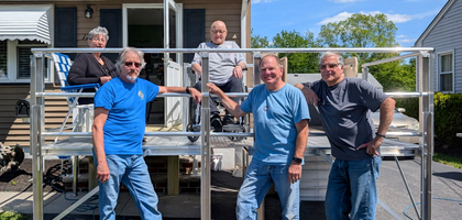 Knights from South Plainfield (N.J.) Council 6203 stand with Sacred Heart parishioners in front of a handicap ramp and lift recently installed at their home. Council 6203 covered the $5,000 cost and has built more than 40 ramps for residents in need since 2011.