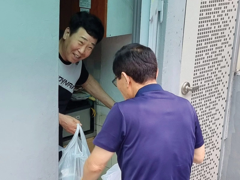 A man receives a meal from Choi Kumwook, a member of St. Peter Yi Ho-yong Council 17799 in Bucheon, South Korea.