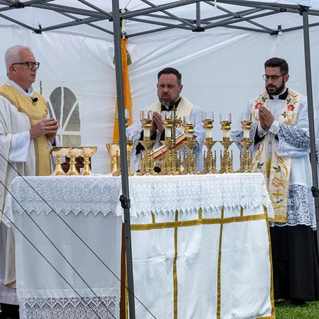 From left, Bishop Donald Hying of Madison, Father Eric Sternberg and Father Enan Zelinski pray during the Liturgy of the Eucharist in James Madison Park in downtown Madison, Wisconsin on April 27.