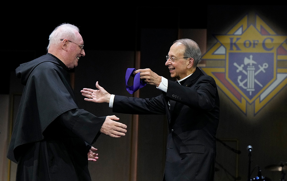 Supreme Chaplain Archbishop William Lori greets Father John Grace before giving him the Blessed Michael McGivney Medal at the Supreme Knight&rsquo;s Award Session, July 31. 