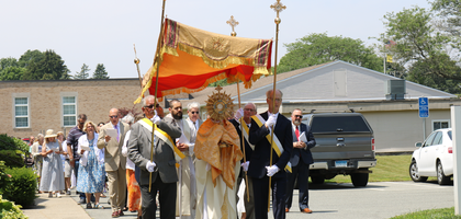 Members of Father Hussion Council 2968 in Old Saybrook, Conn., escort Father Grzegorz Brozonowicz, pastor of St. Pio Parish and a brother Knight, as he carries the monstrance during a Eucharistic procession on Corpus Christi Sunday. Council 2968 organized the event, and about 120 people followed the Eucharist nearly one mile around the parish grounds.