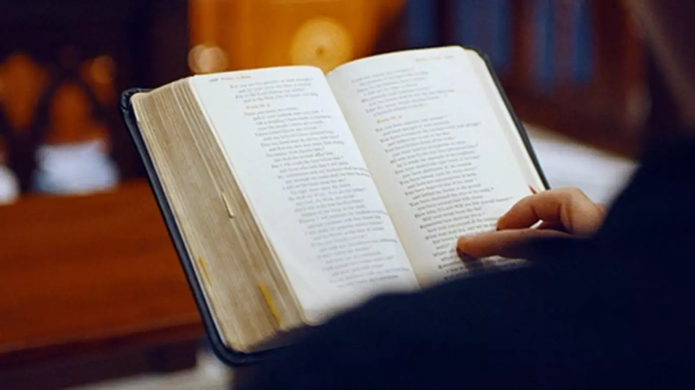 Over the shoulder shot of a man reading the bible.